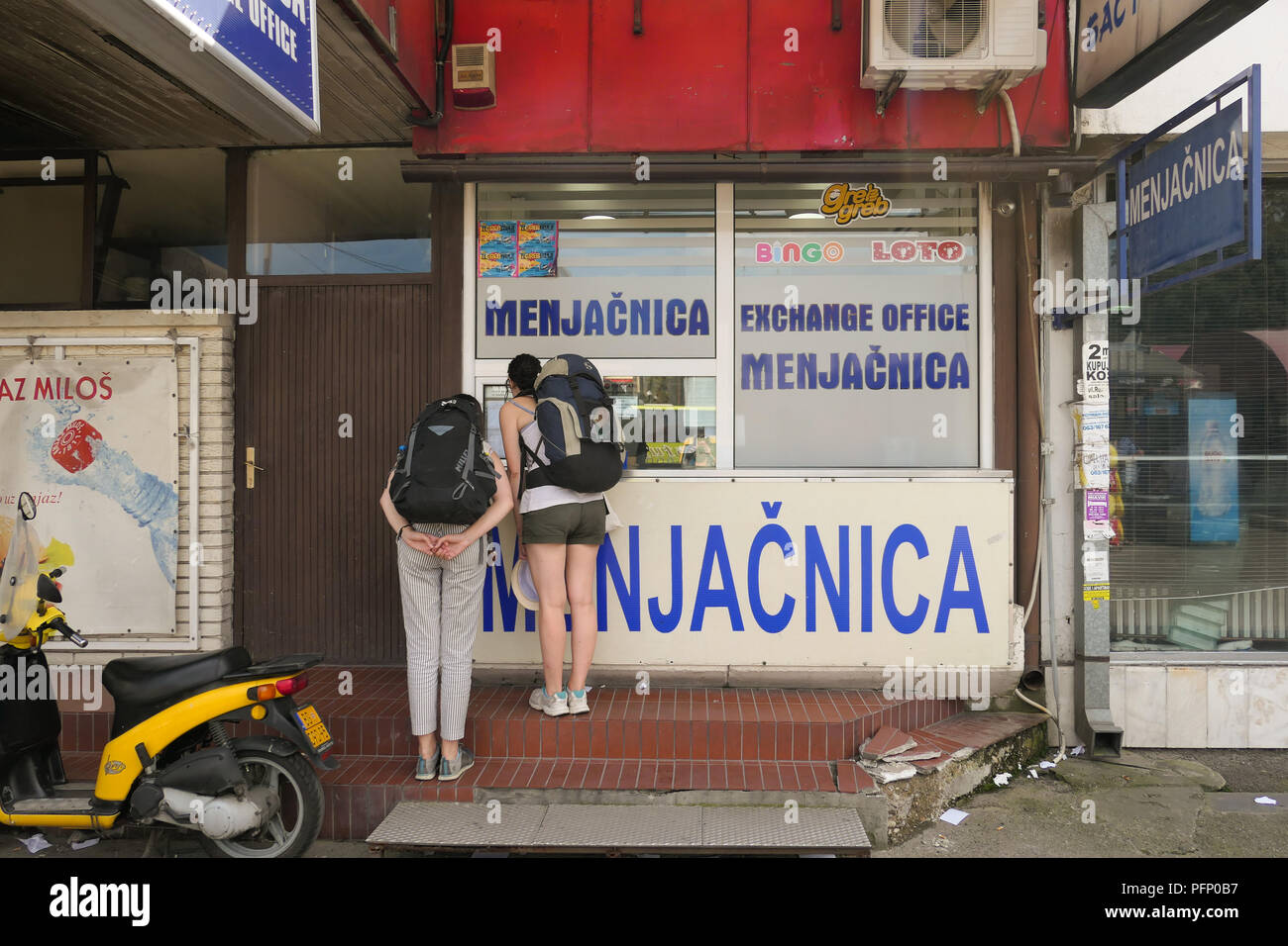 I turisti controllare i tassi di cambio a un Menjacnica - ufficio di scambio - a Belgrado in Serbia Foto Stock