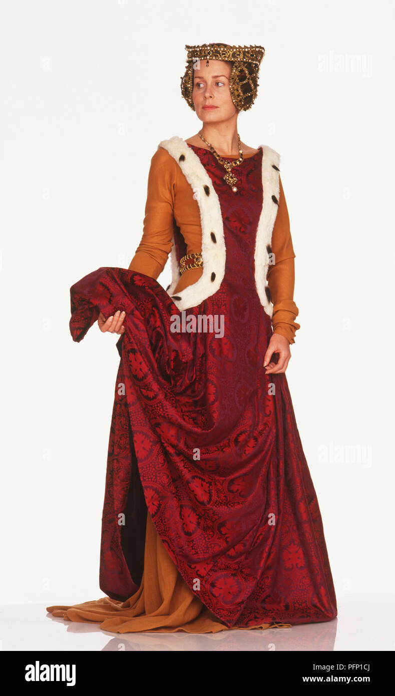Una donna che indossa ornati, copricapo rosso lungo abito di brocade e giacca arancione, lati rifilati con pelo Foto Stock