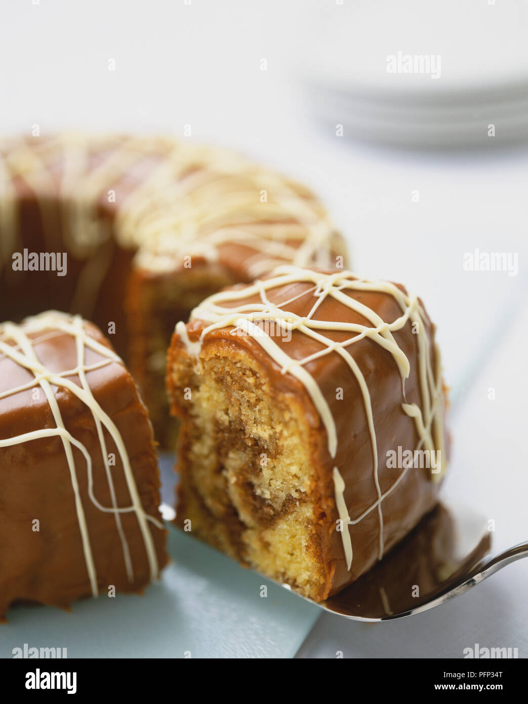Caffè in Marmo torta ad anello con sezione essendo sollevato fuori con una fetta di torta. Foto Stock