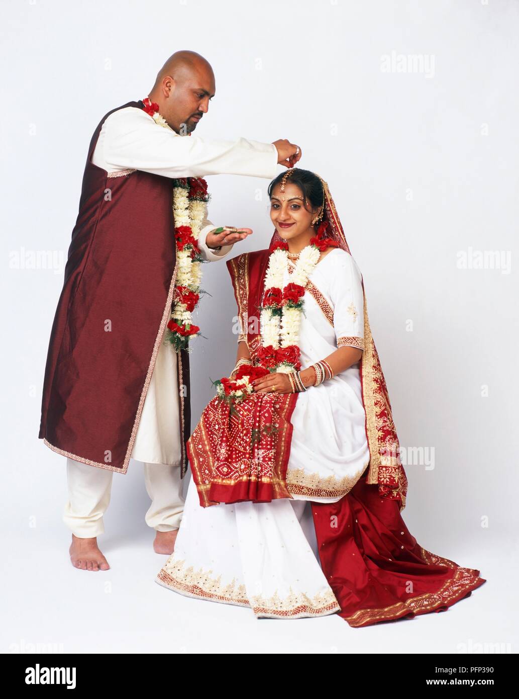 Hindu rituale di nozze chiamato sindoor daan, sposo spolverata vermiglio in polvere nella troncatura di sposa i capelli, close-up Foto Stock
