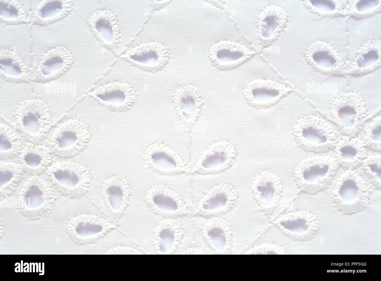 Occhielli ricamati su tessuto bianco utilizzando Broderie Anglaise cucito Foto Stock