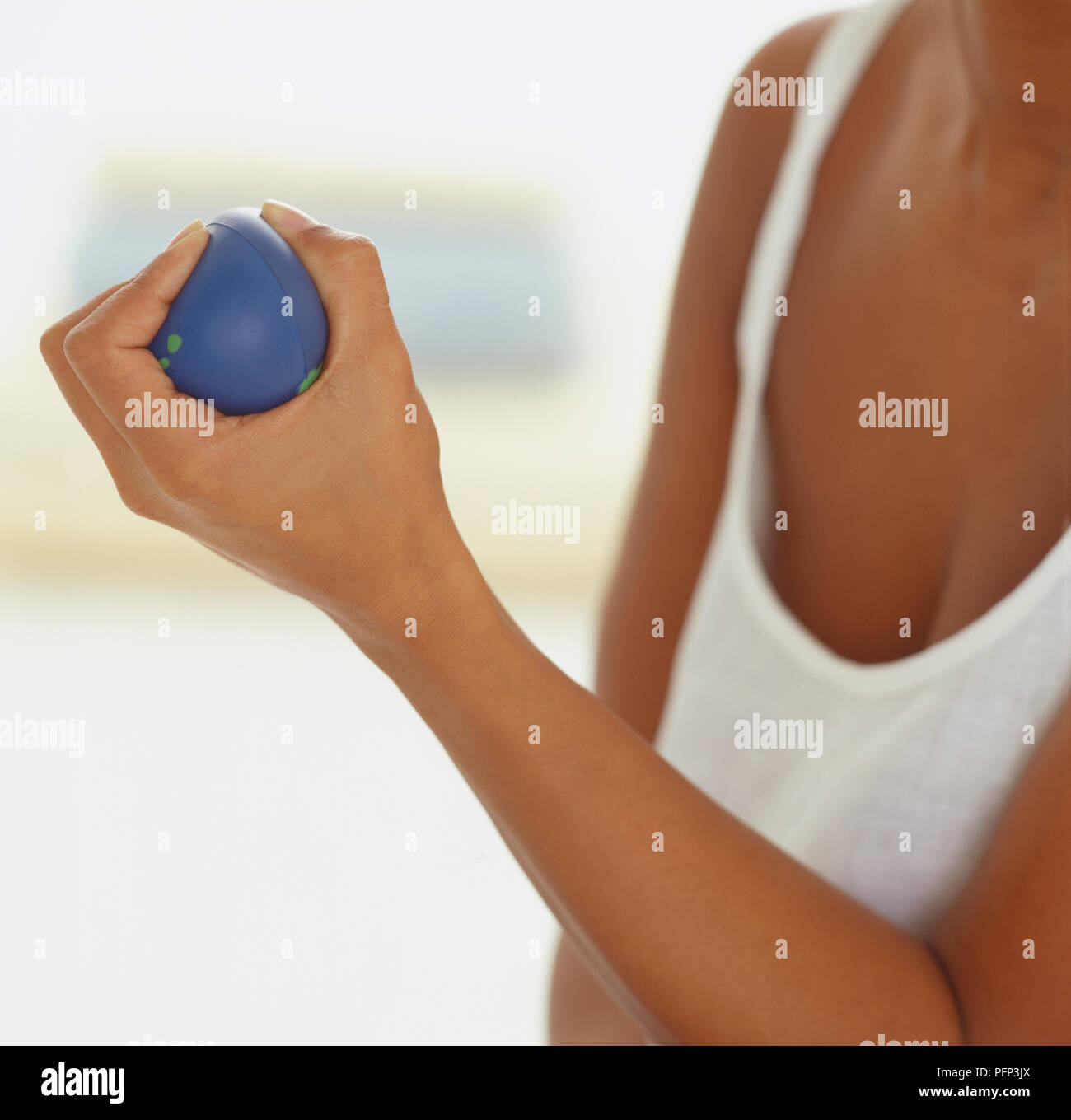 La donna la spremitura di una sfera blu, vicino. Foto Stock