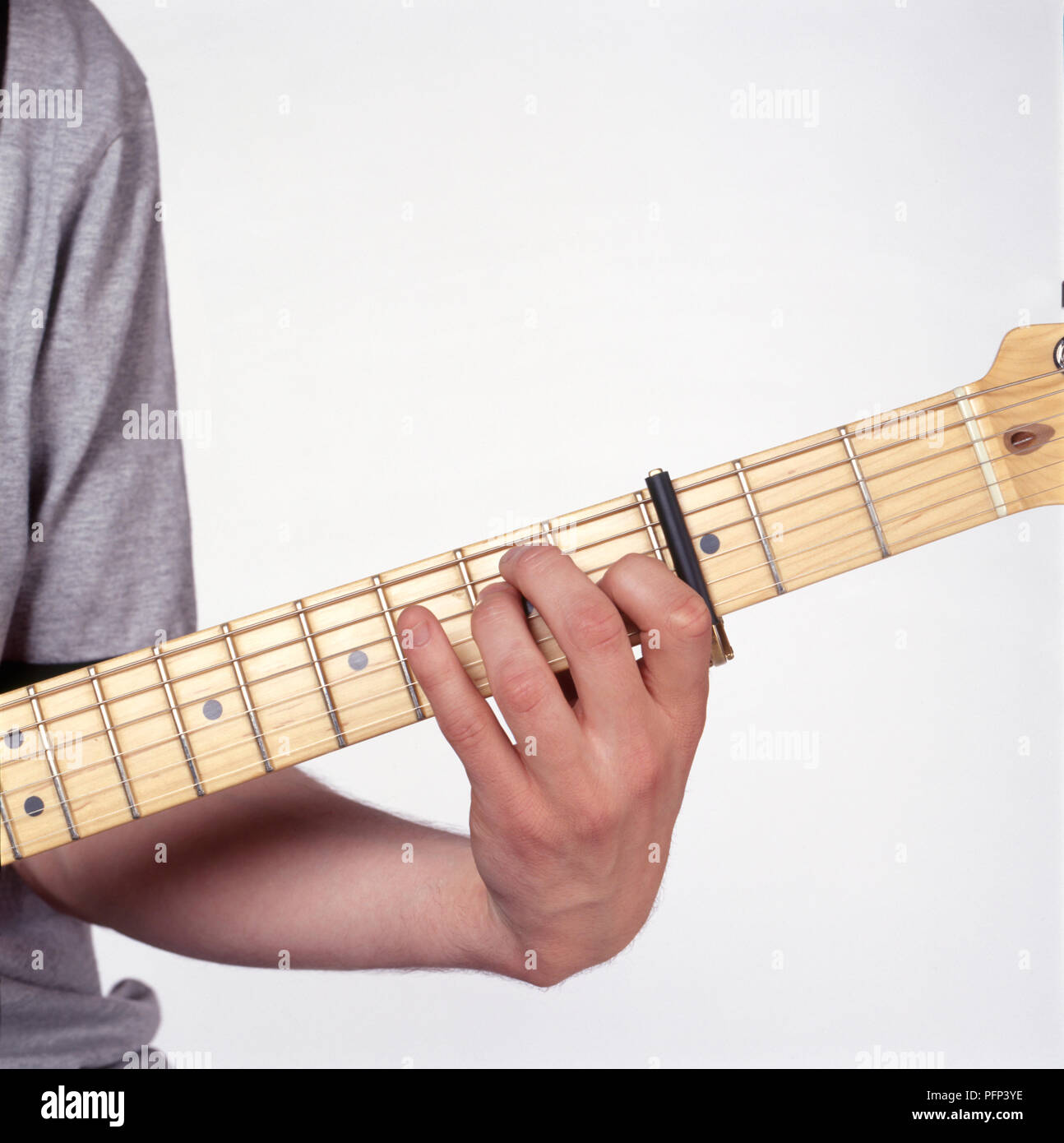 Le dita su una chitarra, giocando G major, posizione aperta, con capotasto, close-up Foto Stock