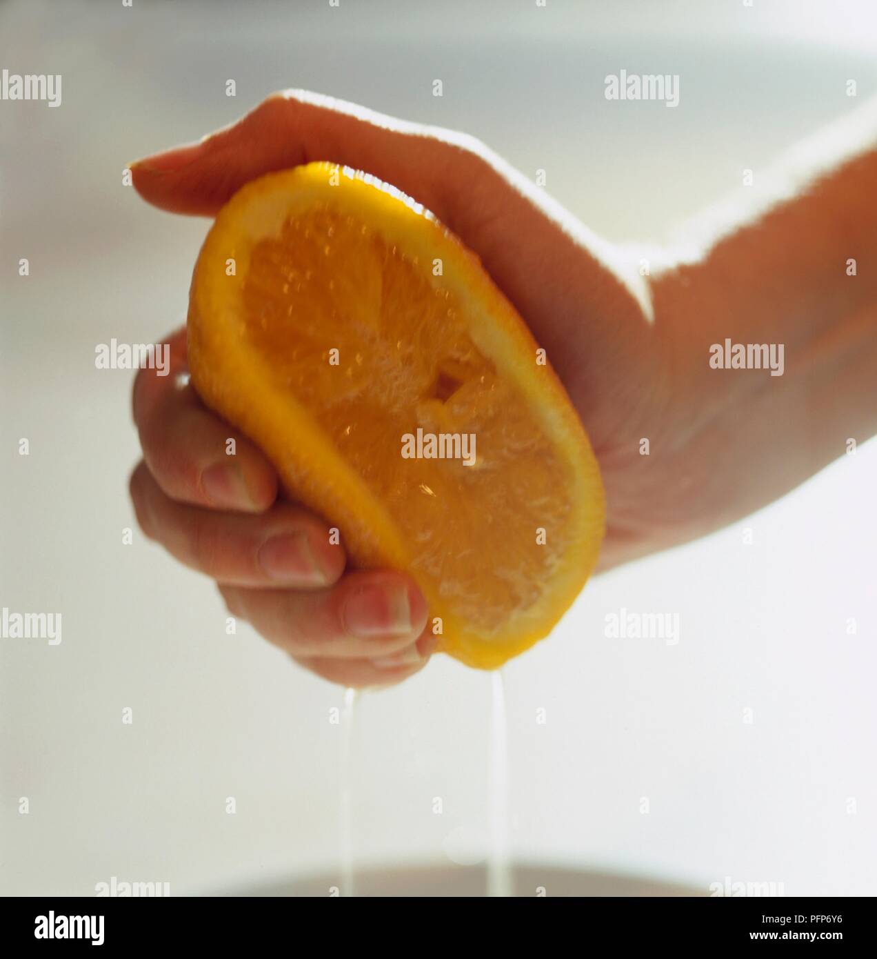 Spremitura a mano di colore arancione, close-up Foto Stock