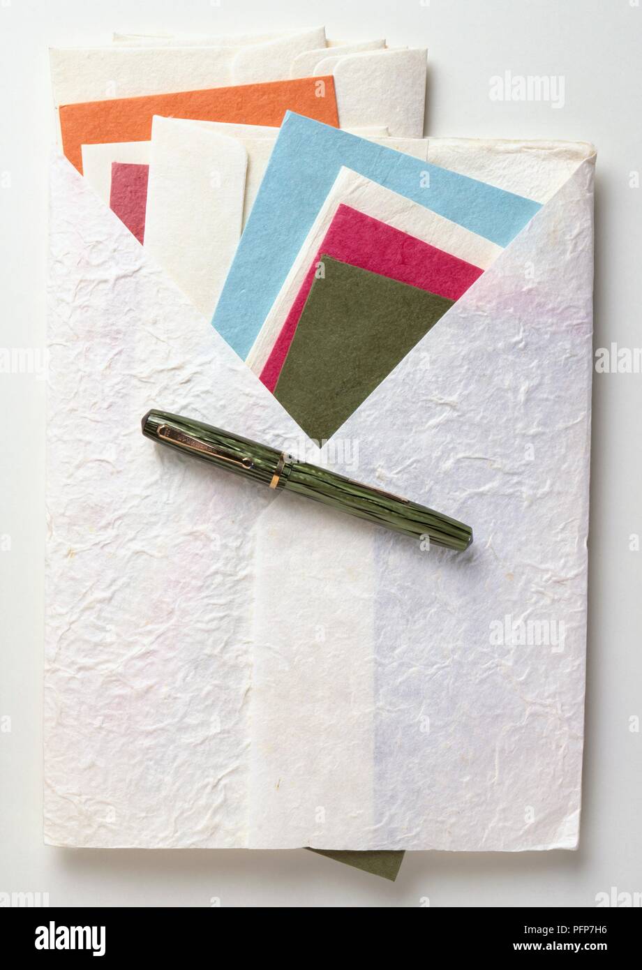 Vari fatti a mano di carte e buste in carta bianca cartella, con una penna stilografica sulla parte superiore Foto Stock
