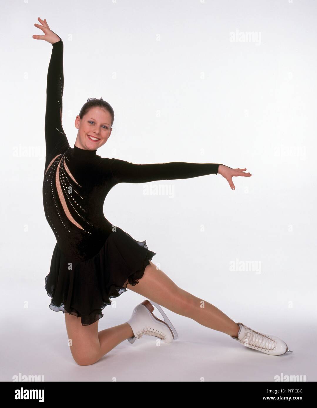 Ragazza adolescente nel pattinaggio sul ghiaccio posizione, indossando abiti  di colore marrone e bianco ghiaccio pattinaggio Foto stock - Alamy