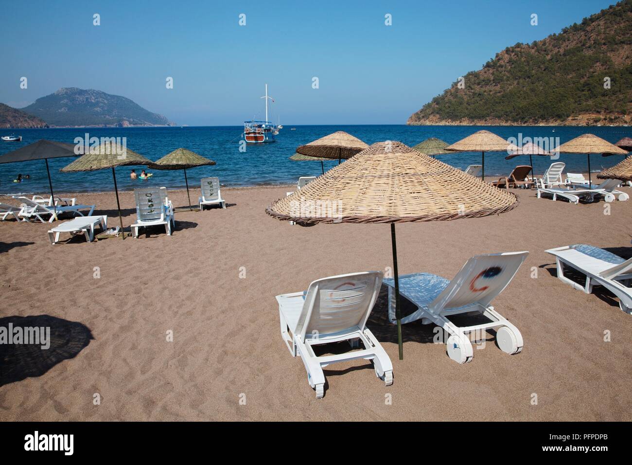 Turchia, sedie a sdraio e palapas sulla Adrasan beach, vicino a Kemer Foto Stock