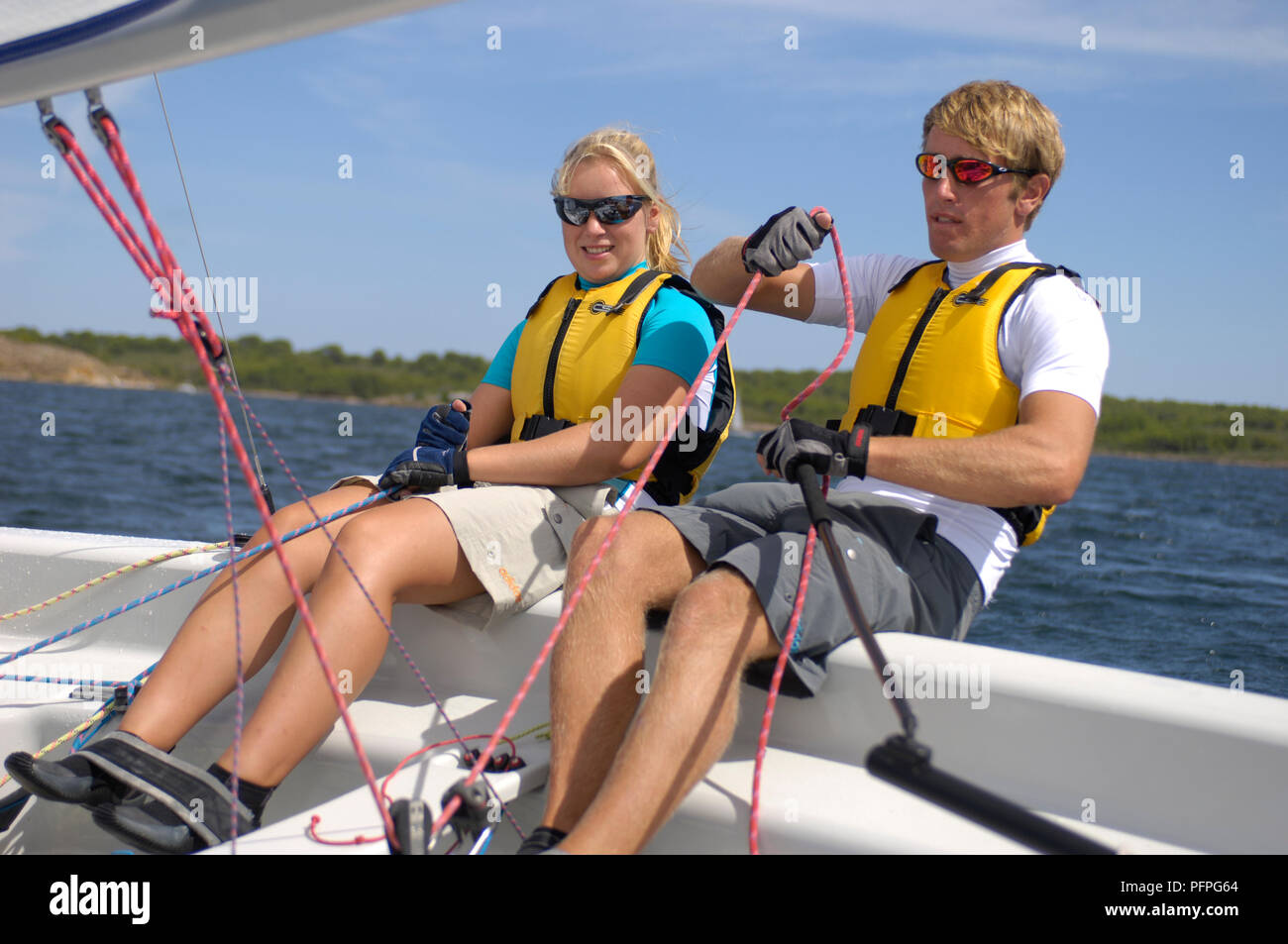 Spagna, Minorca, giovane donna e uomo vela dinghy Foto Stock