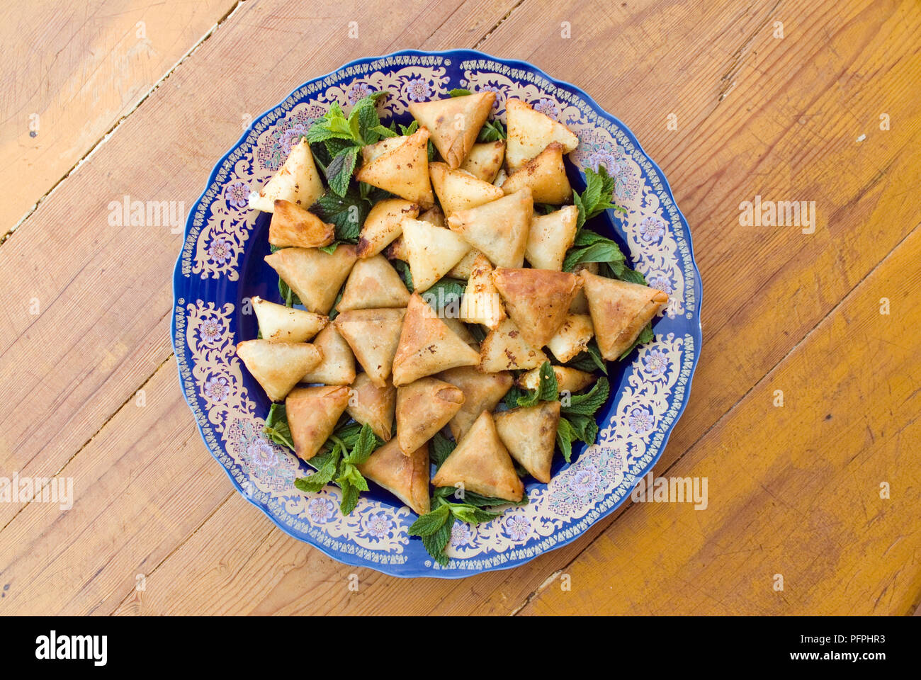 Briouat, Marocchina Puff Pastry pacchi con ripieno di carne e guarnite con foglie di menta Foto Stock
