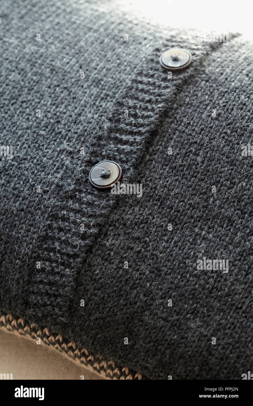 Pulsanti sul retro della maglia grigio fodera per cuscino, close-up Foto Stock
