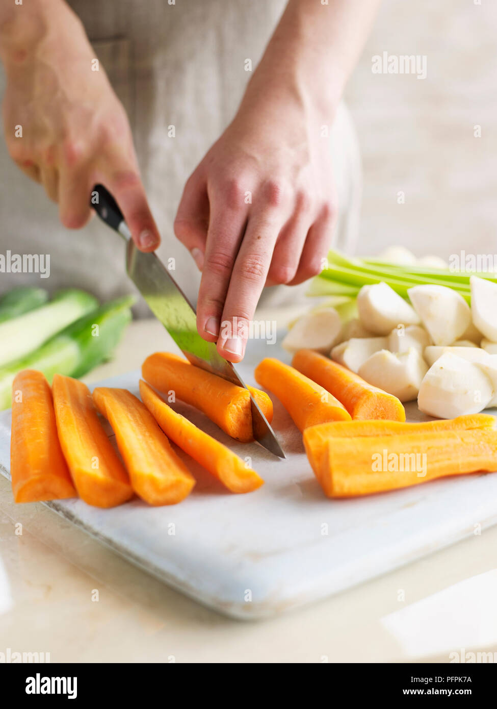 Tritare le carote e altri ortaggi (ingredienti per il Pot au Feu) Foto Stock