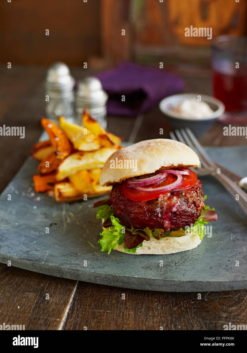 Carni bovine, barbabietole e stilton burger in bap, servita con verdure chips Foto Stock Carni bovine, barbabietole e stilton burger in bap, servita con verdure chips Foto Stock