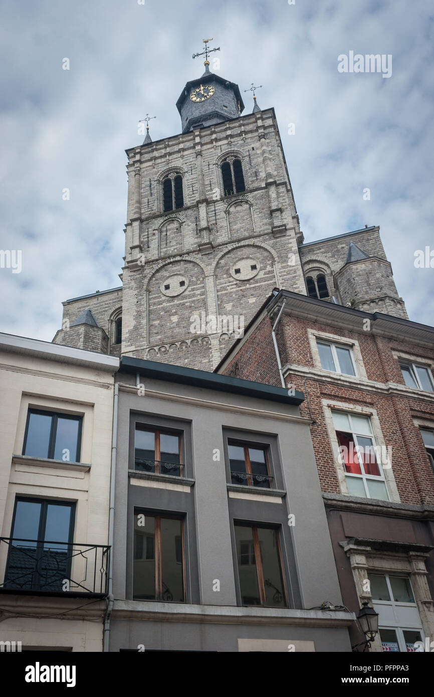 Il vecchio incontra il nuovo come la guglia di San Germano chiesa in Tienen, Belgio, torri oltre il diciannovesimo secolo appartamenti in centro. Foto Stock