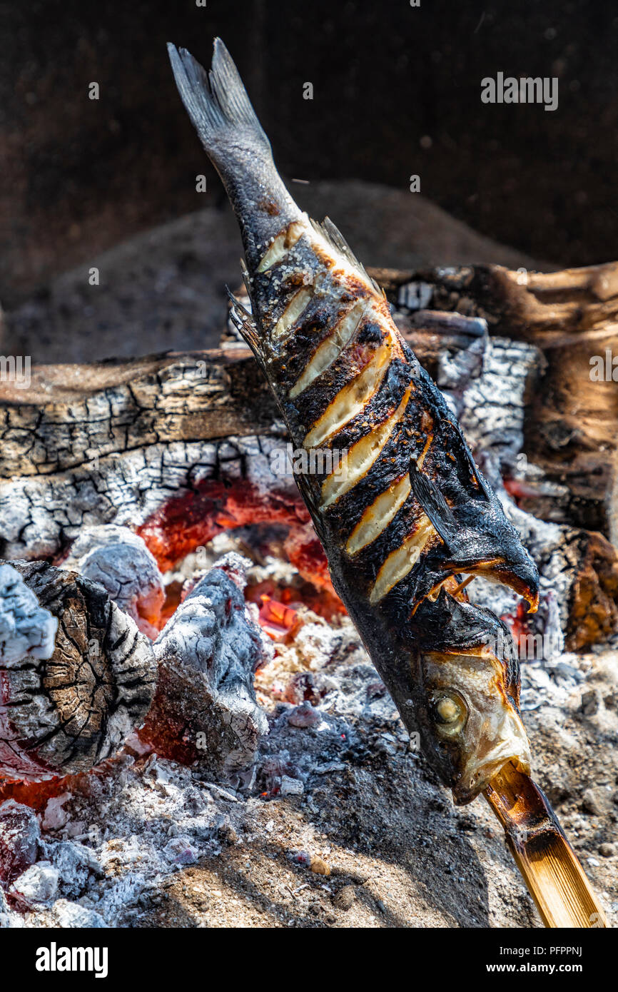 Il pesce fresco viene cucinato in un registro aperto forno, Nerja, Spagna.r Foto Stock
