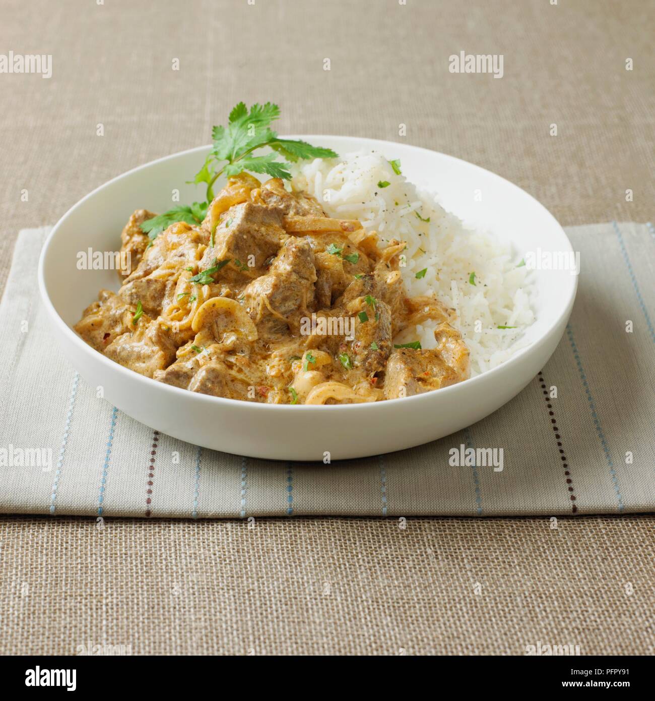 Ciotola di agnello Korma con riso e coriandolo Foto Stock