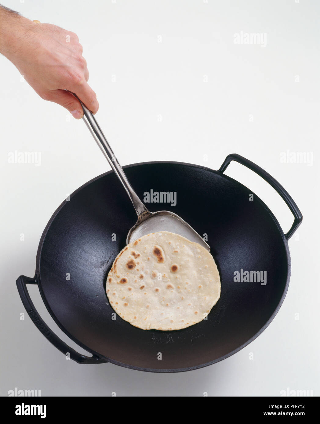 Girando cinese pancake nel wok Foto Stock