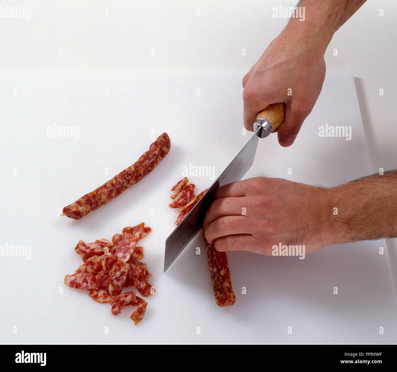 Uomo con carni cleaver per affettare materie cinese di salsiccia di maiale Foto Stock