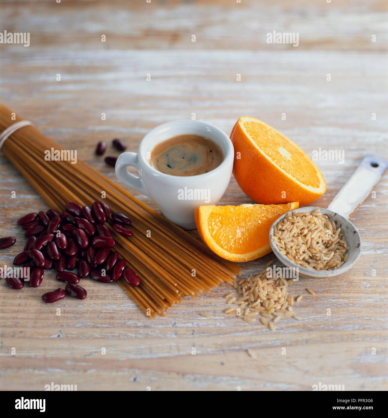 Tazza di caffè, fettine di arancia, riso marrone, integrali (frumento integrale) spaghetti e fagioli rossi Foto Stock