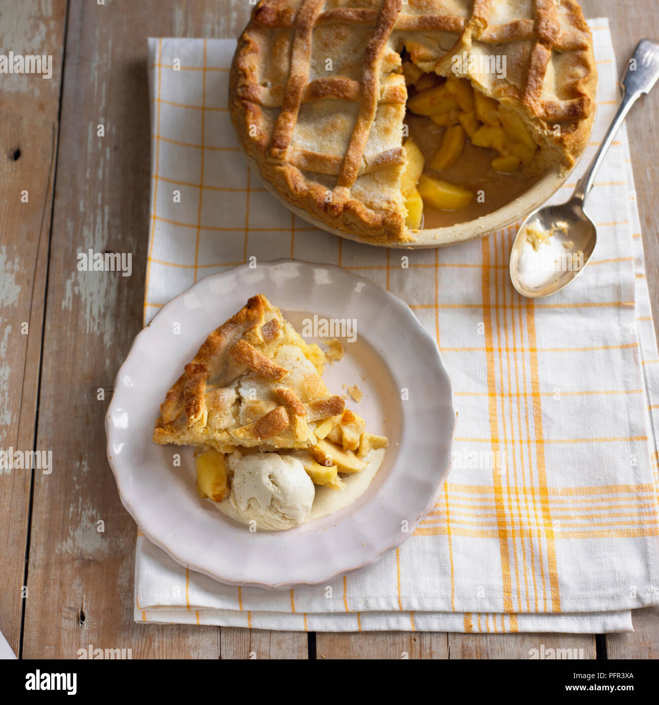 Torta di mele con fetta tagliata e servita su piastra separata con gelato Foto Stock