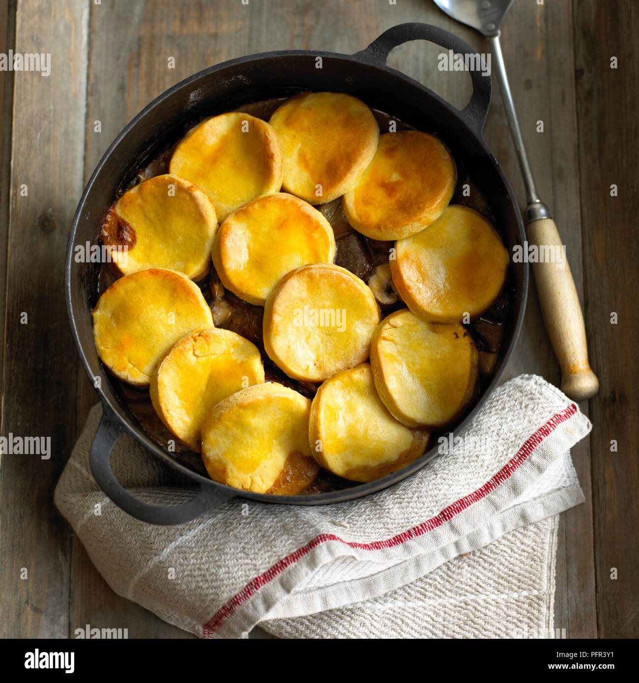 Carni bovine, finocchio e fungo cobbler in ghisa pan, con cucchiaio Foto Stock