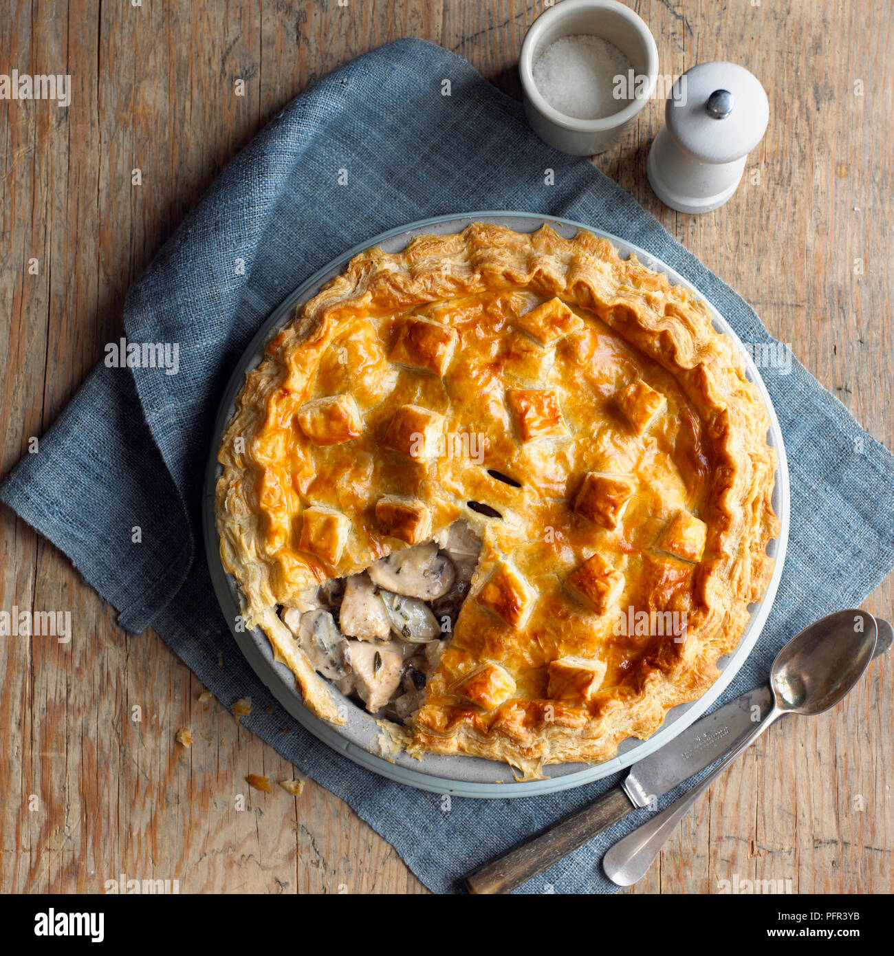 Funghi selvatici e la faraona torta sul tavolo, con sale e pepe, mulino, e posate Foto Stock