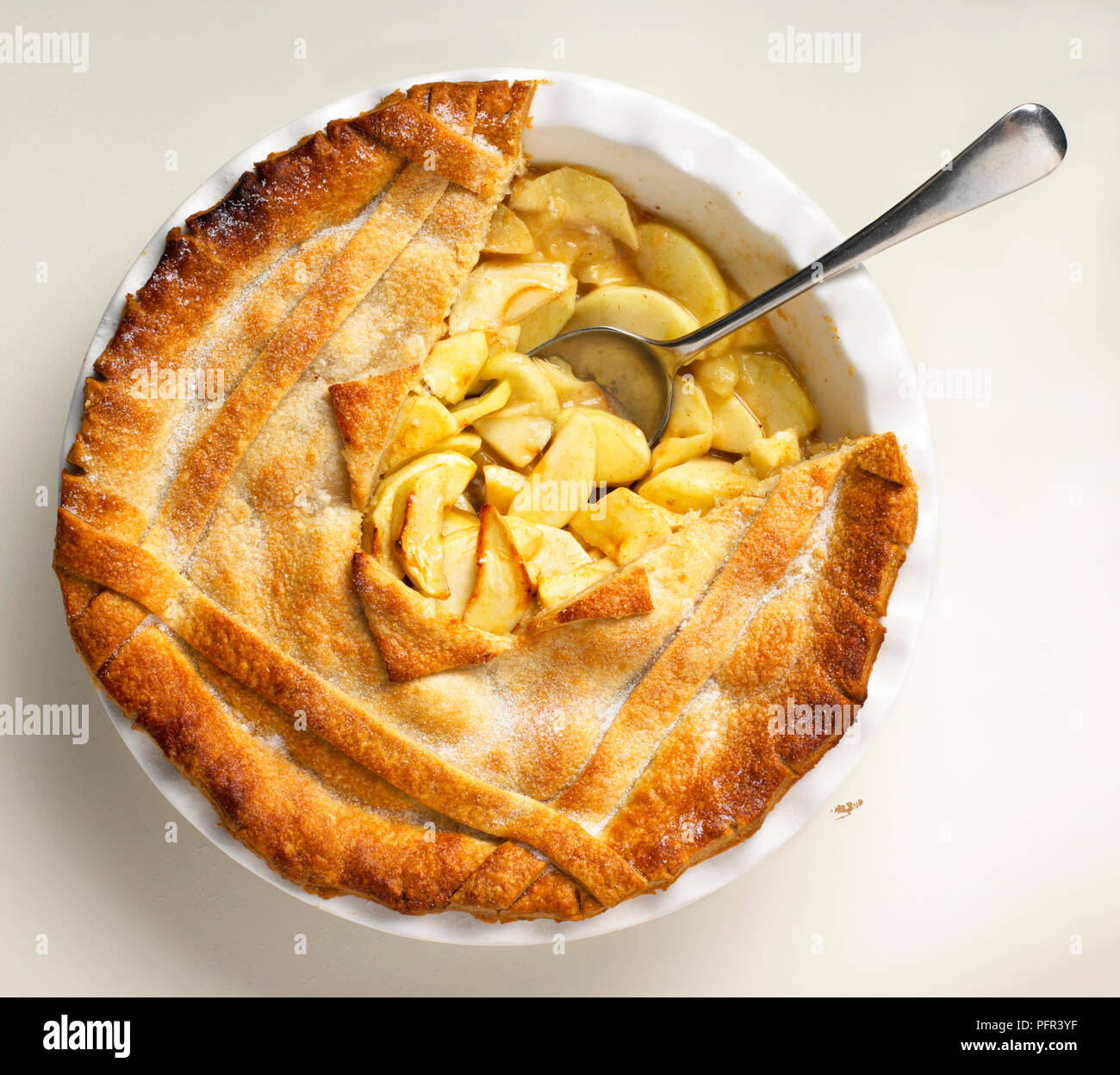 La torta di mele con parte della crosta rimossa, che mostra il riempimento di apple e cucchiaio Foto Stock
