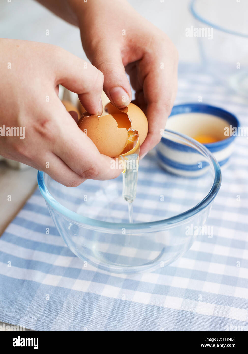 Uovo di rottura sulla ciotola, dividere o separare le uova Foto Stock
