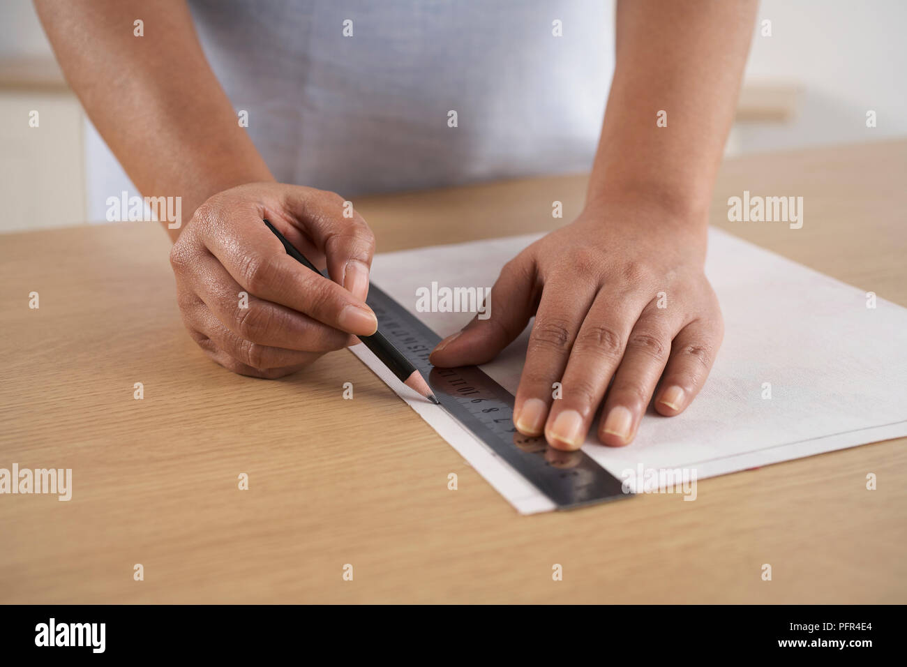 La realizzazione di un dispositivo di protezione, segnando una linea di cucitura 1 cm dai bordi di interfacciamento Foto Stock