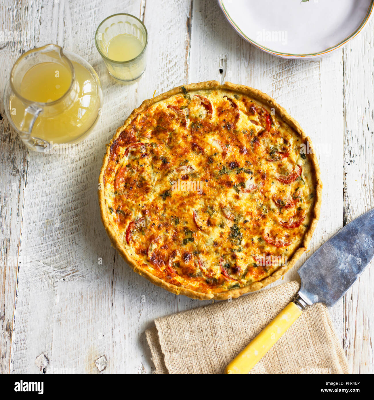 Pomodoro e Digione crostata con parmigiano e basilico crosta, brocca e vetro contenente soft drink Foto Stock