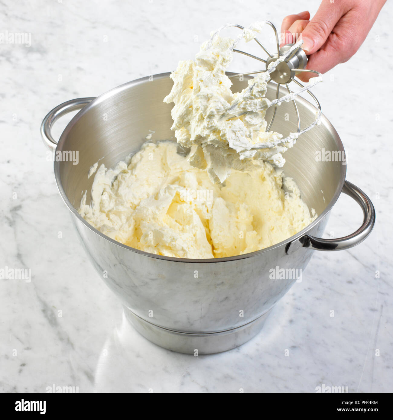 Glassa di crema di burro nel recipiente del robot da cucina Foto Stock