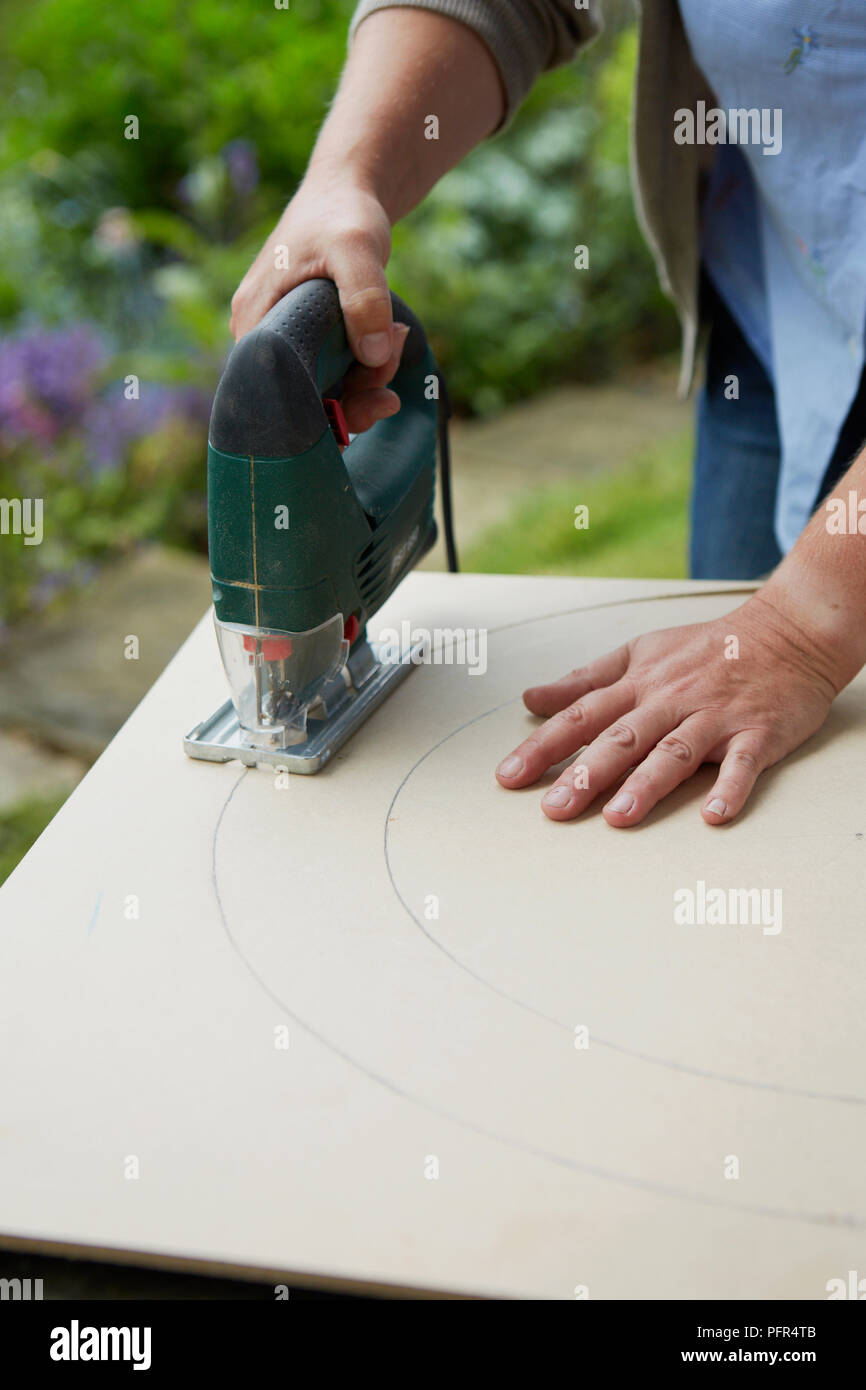 Rendendo omaggio floreale il telaio dello specchietto, MDF di taglio a forma usando un seghetto alternativo Foto Stock