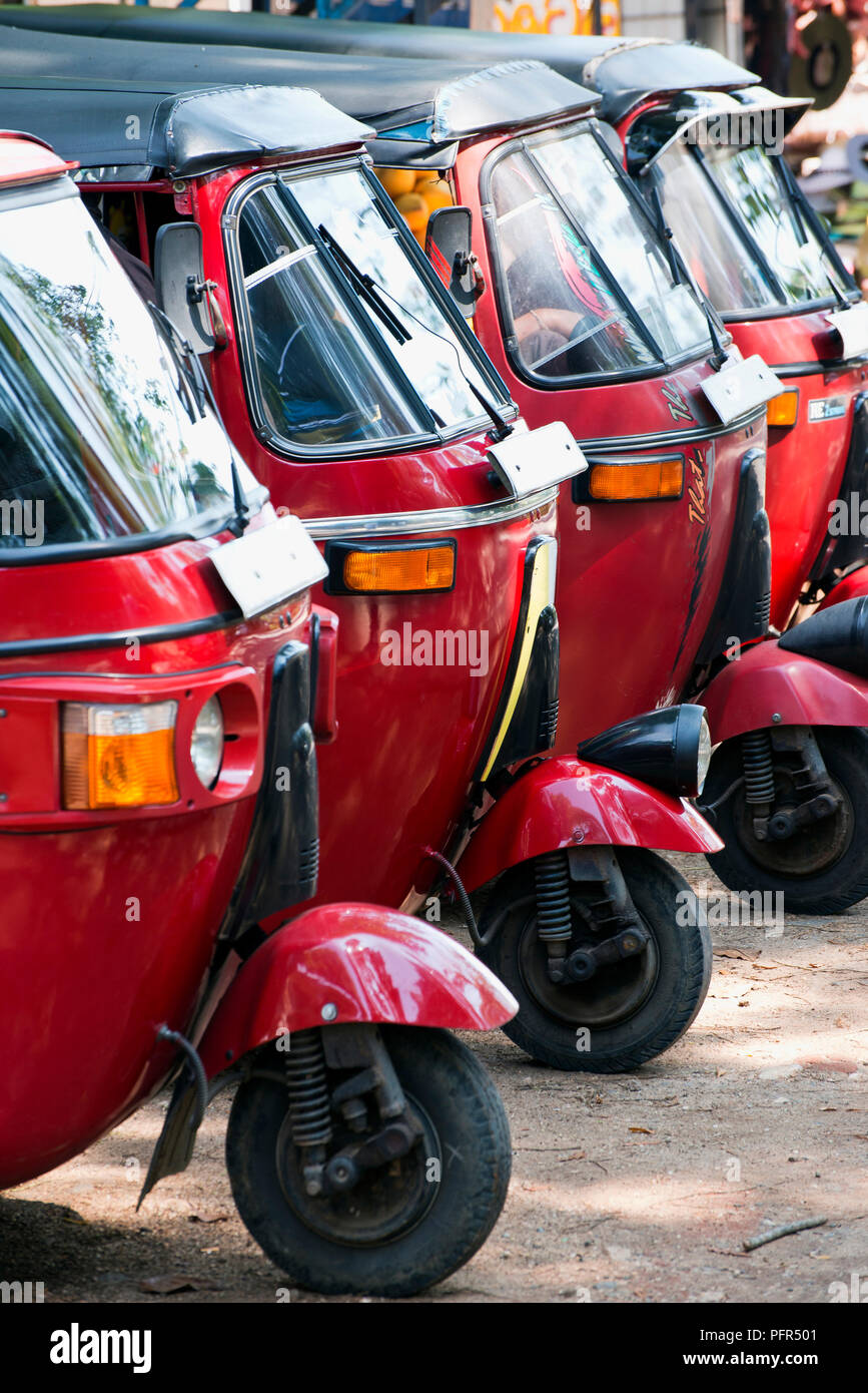 Sri Lanka, Sabaragamuwa Provincia, Rambukkana, Pinnawala l'Orfanotrofio degli Elefanti, rosso di tuk-tuks (tre ruote di risciò motorizzati) parcheggiata in una linea Foto Stock