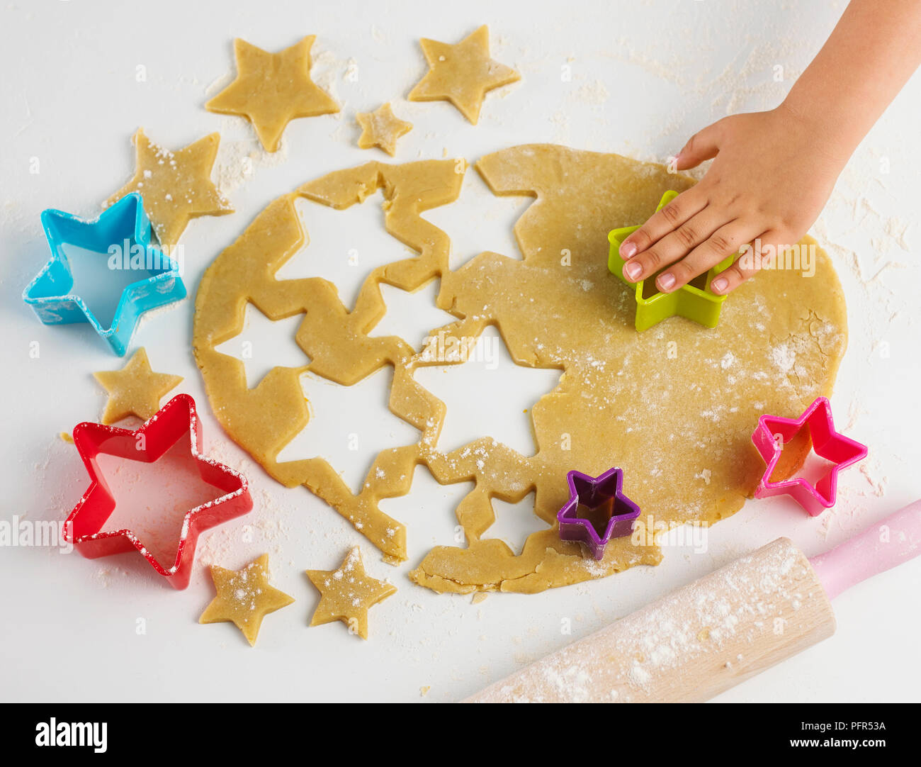 Il taglio di forme stellari dalla pasta biscotto Foto Stock
