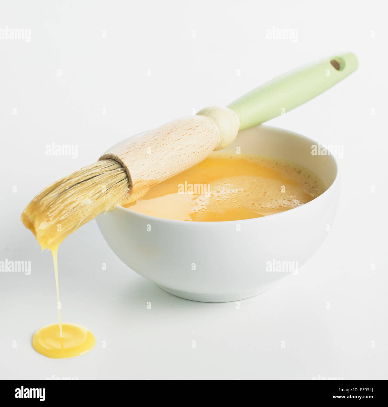 Ciotola di uova sbattute e una spazzola di pasticceria Foto Stock