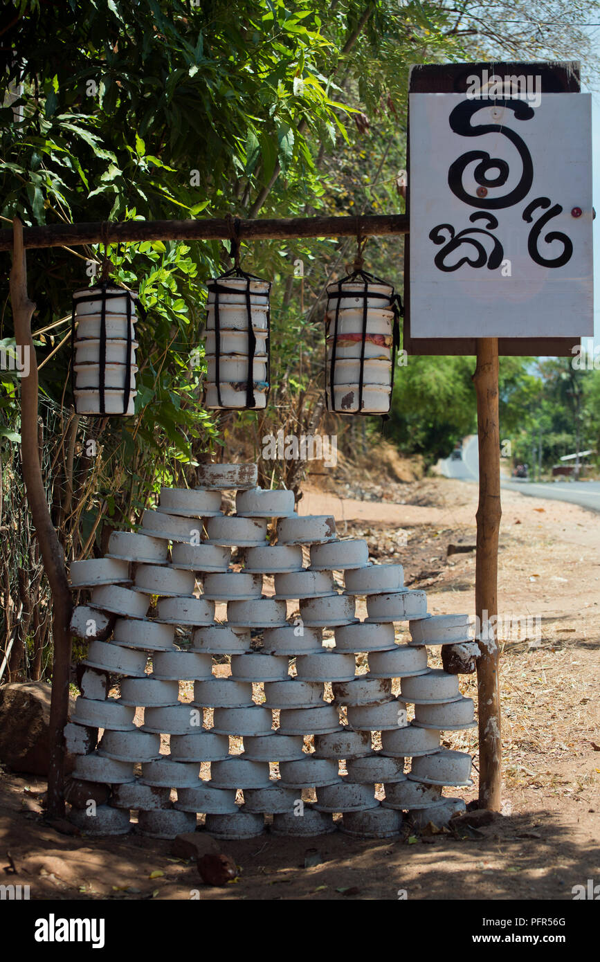 Sri Lanka, provincia di Uva, Wellawaya, la pila di vaschette e segno su strada Foto Stock