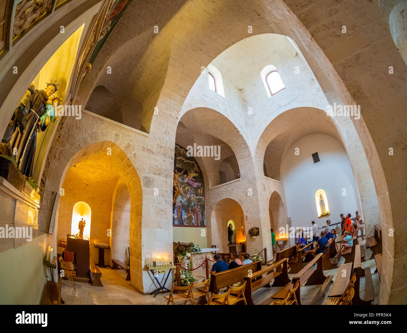 Alberobello, Italia - Agosto 15, 2018: i turisti in visita all'interno della famosa architettura del Trullo-chiesa nel villaggio di Trulli di Alberobello Foto Stock