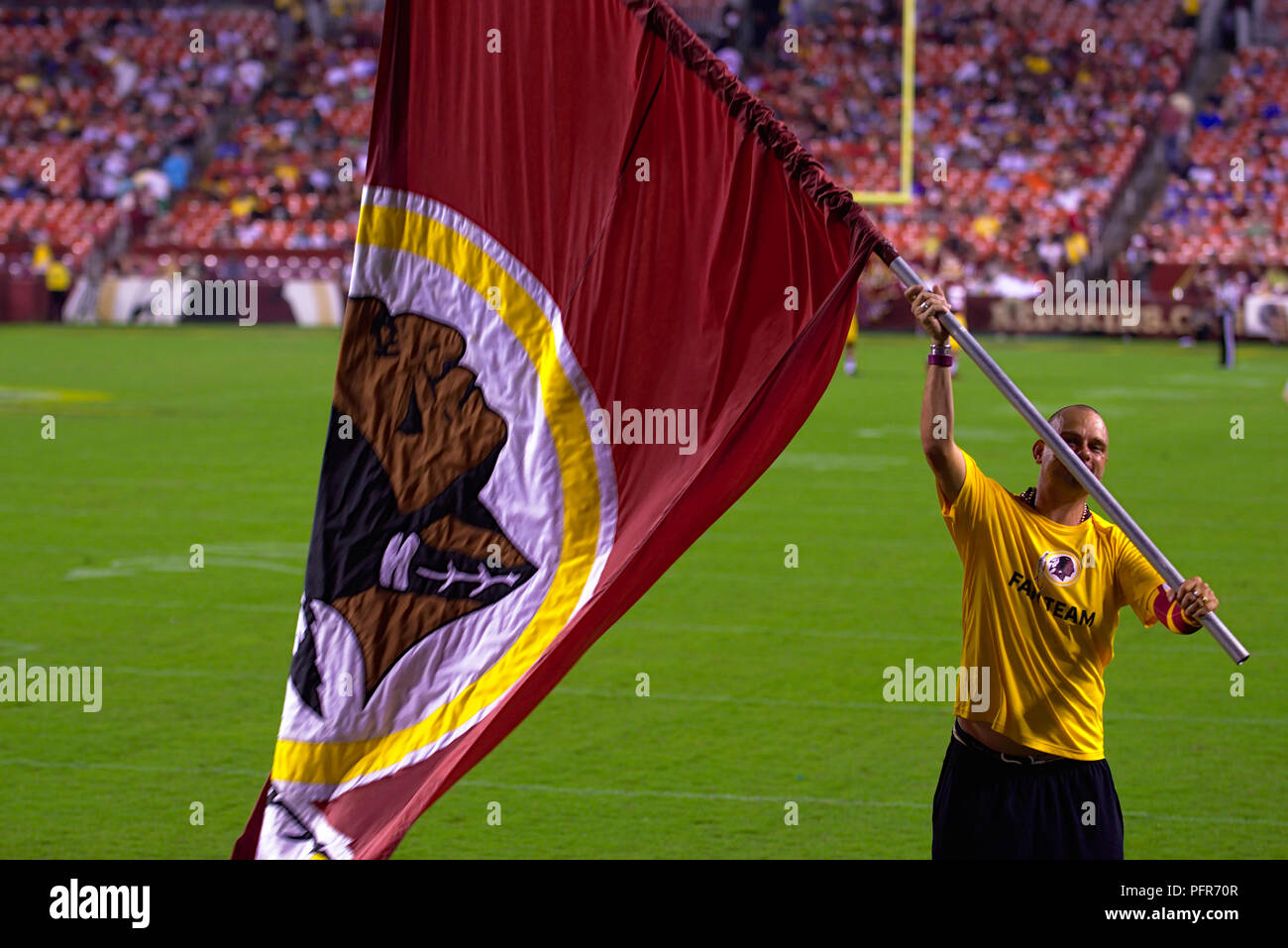 Voce maschile del personale del team Redskins sventola bandiera durante il timeout di preseason game Foto Stock