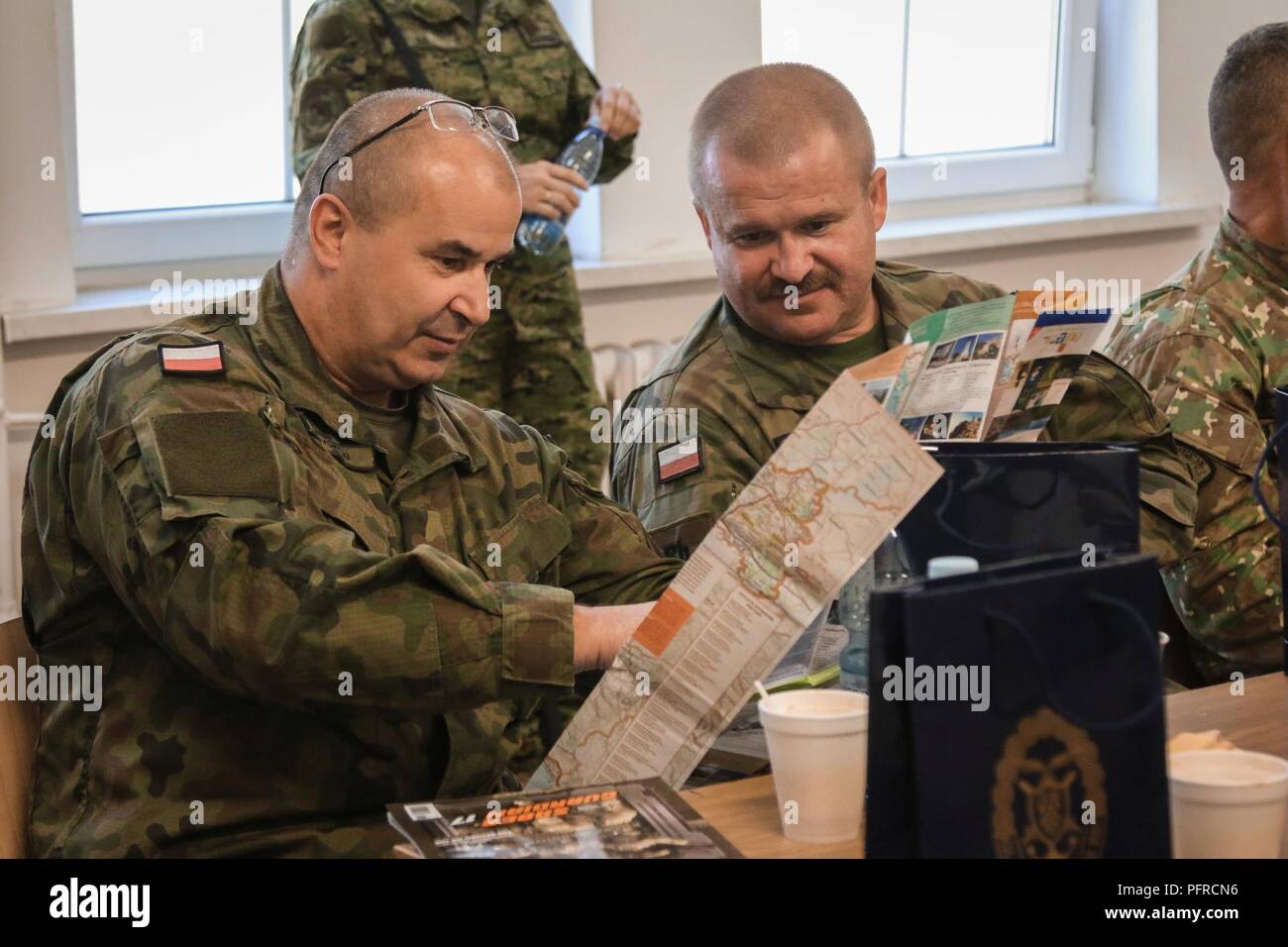 Esercito Polacco soldati con la XV Brigata meccanizzata, guardare regali ricevuti dall'esercito croato del razzo di artiglieria "Storm" batteria, durante una presentazione in onore del croato Forze Armate giorno a Bemowo Piskie Area Formazione, Polonia, 28 maggio 2018. Gruppo di combattimento della Polonia è un luogo unico e multinazionale di coalizione di Stati Uniti, Regno Unito, croato e soldati rumeni che servono con il polacco della XV Brigata meccanizzata come una forza di dissuasione a sostegno della NATO in avanti rafforzata presenza. Foto Stock