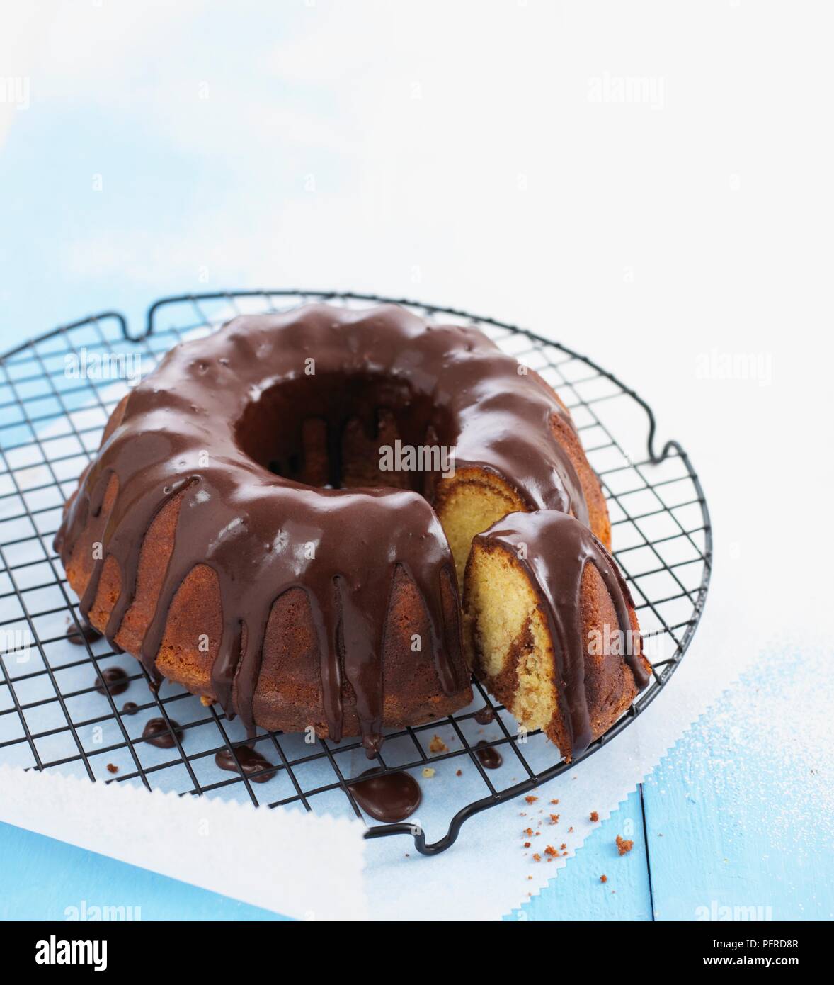 Marmo torta con glassa di cioccolato su un raffreddamento per rack, singola fetta tagliata via Foto Stock