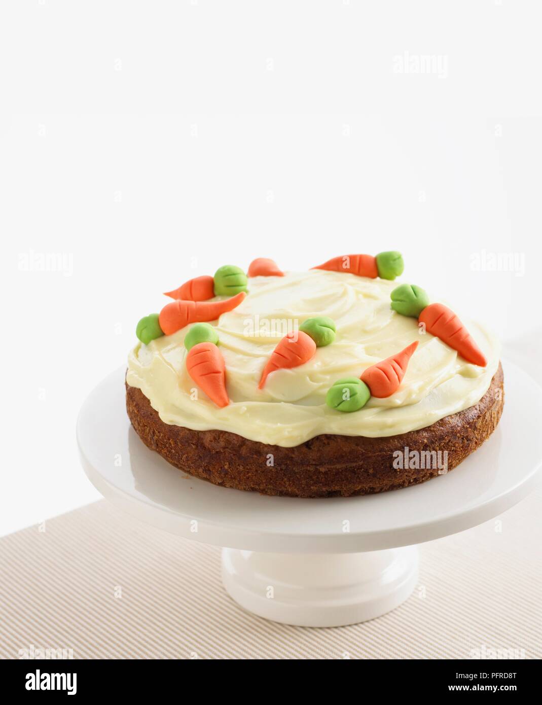 Torta di carote con glassa di formaggio cremoso e carota decorazione su una torta di stand Foto Stock