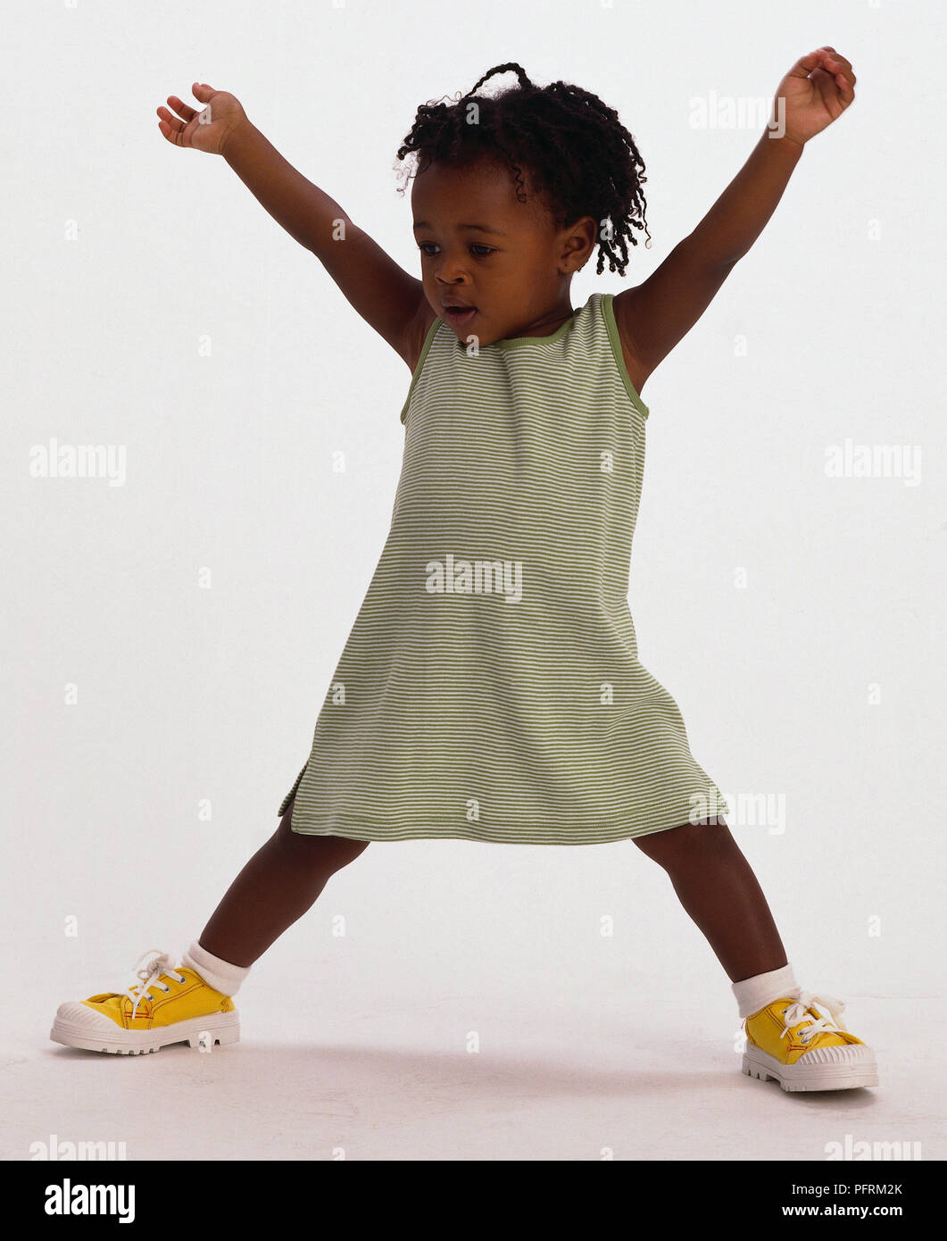 Il Toddler indossando abito bianco in piedi in forma di stella Foto Stock