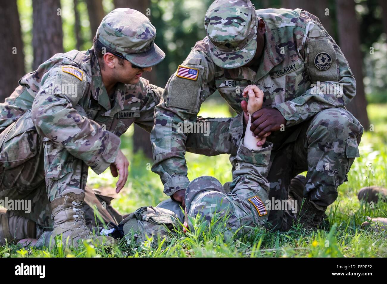 Spc. Steve Scheel (sinistra), Mukilteo, nativo di Washington, combattere medic con il primo squadrone, 2° reggimento di cavalleria,insegna Spc. Dario Ledet (a destra), Lafayette, Louisiana nativo, fuoco indiretto fantassin con il primo squadrone, 2° reggimento di cavalleria, come controllare un soldato di impulso dei durante il combattimento ancora di salvezza la formazione con gruppo di combattimento della Polonia a Bemowo Piskie Area Formazione, Polonia, 31 maggio 2018. Gruppo di combattimento della Polonia è un luogo unico e multinazionale di coalizione di Stati Uniti, Regno Unito, croato e soldati rumeni che servono con il polacco della XV Brigata meccanizzata come una forza di dissuasione in sostegno della NATO è stato ottimizzato in avanti delle prese Foto Stock