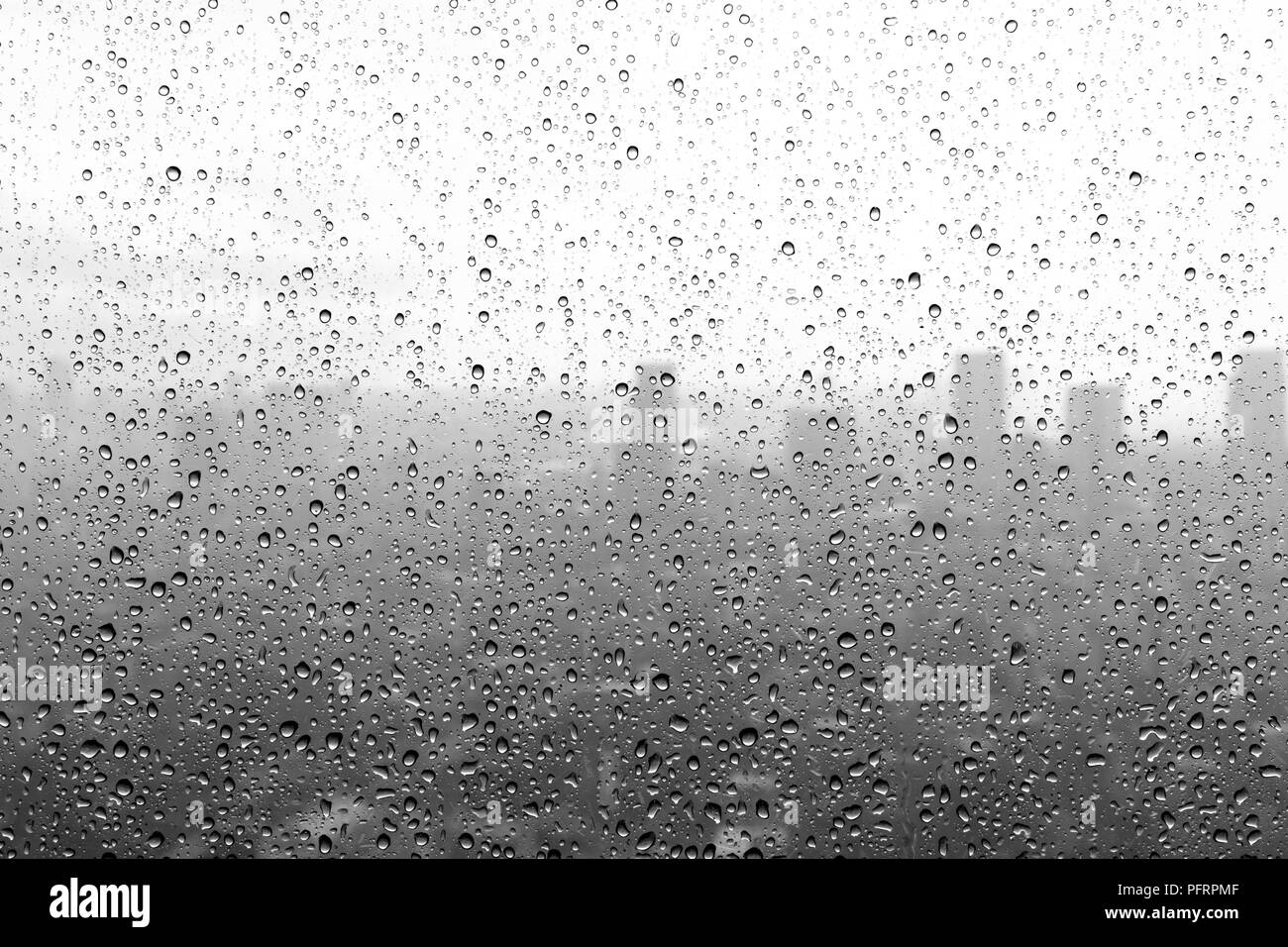 In bianco e nero delle gocce di pioggia su una finestra Foto Stock