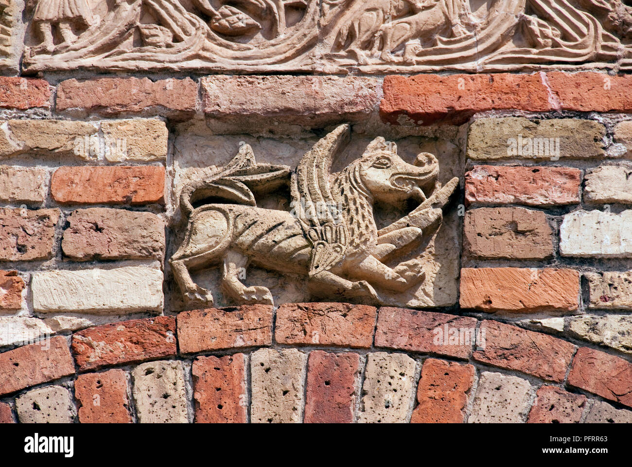 L'Italia, Codigoro, Abbazia di Pomposa (Abbazia di Pomposa) stone carving di nicchia del mitico animale alato sulla facciata del monastero benedettino Foto Stock