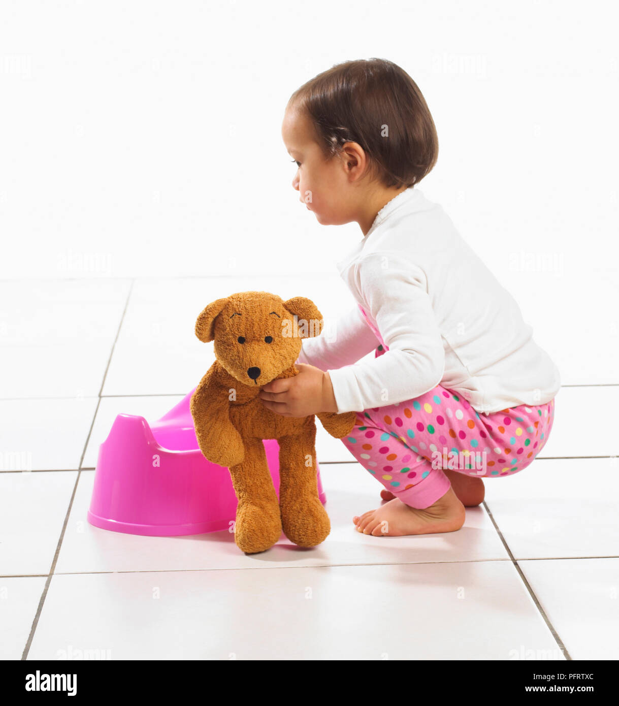 Il Toddler ragazza con vasino e giocattolo morbido, 1,5 anni Foto Stock
