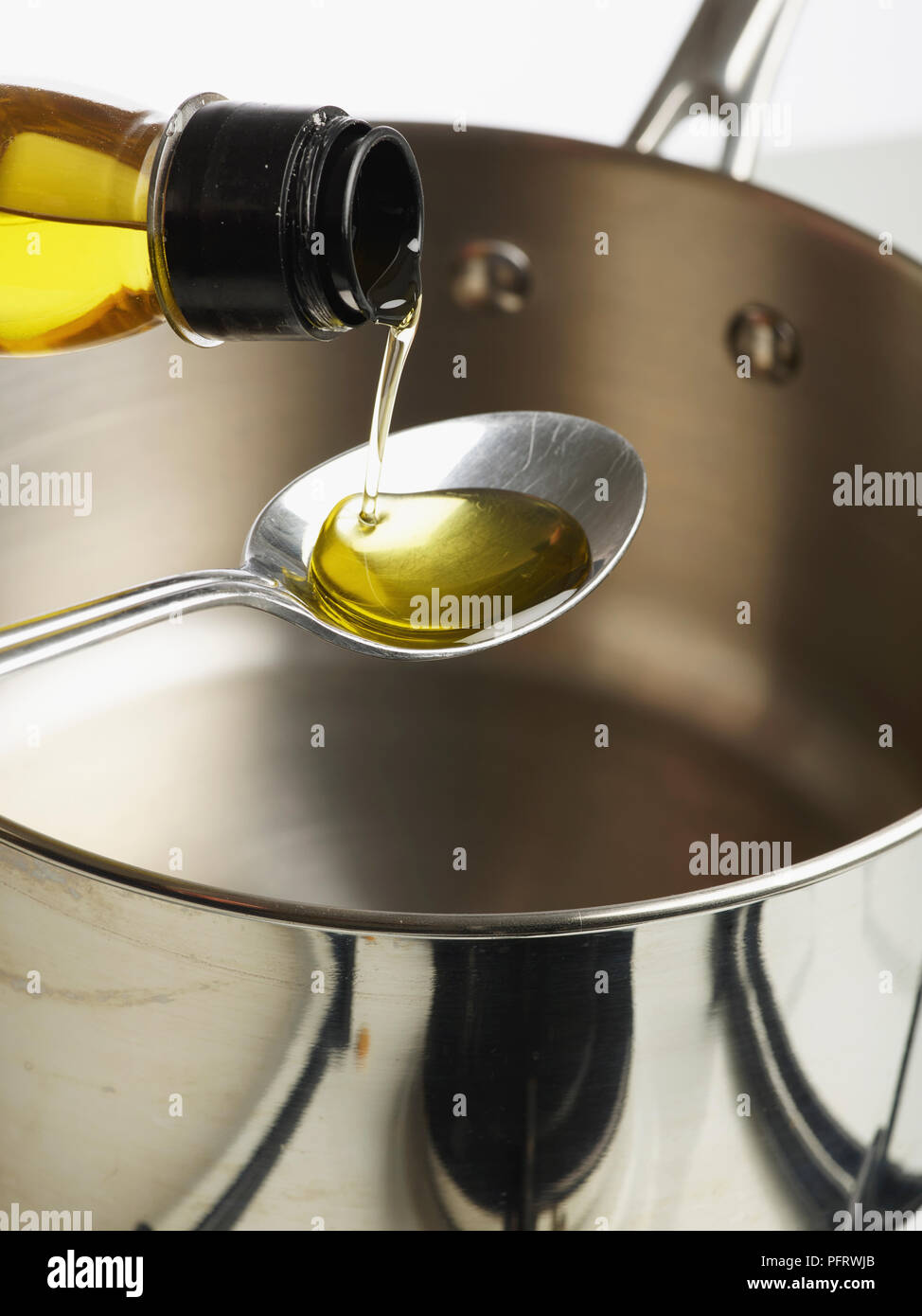 Versando olio sul cucchiaio Foto Stock
