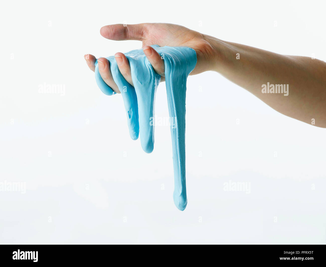 Sticky esperimento di fango, melma blu che corre attraverso le mani Foto Stock