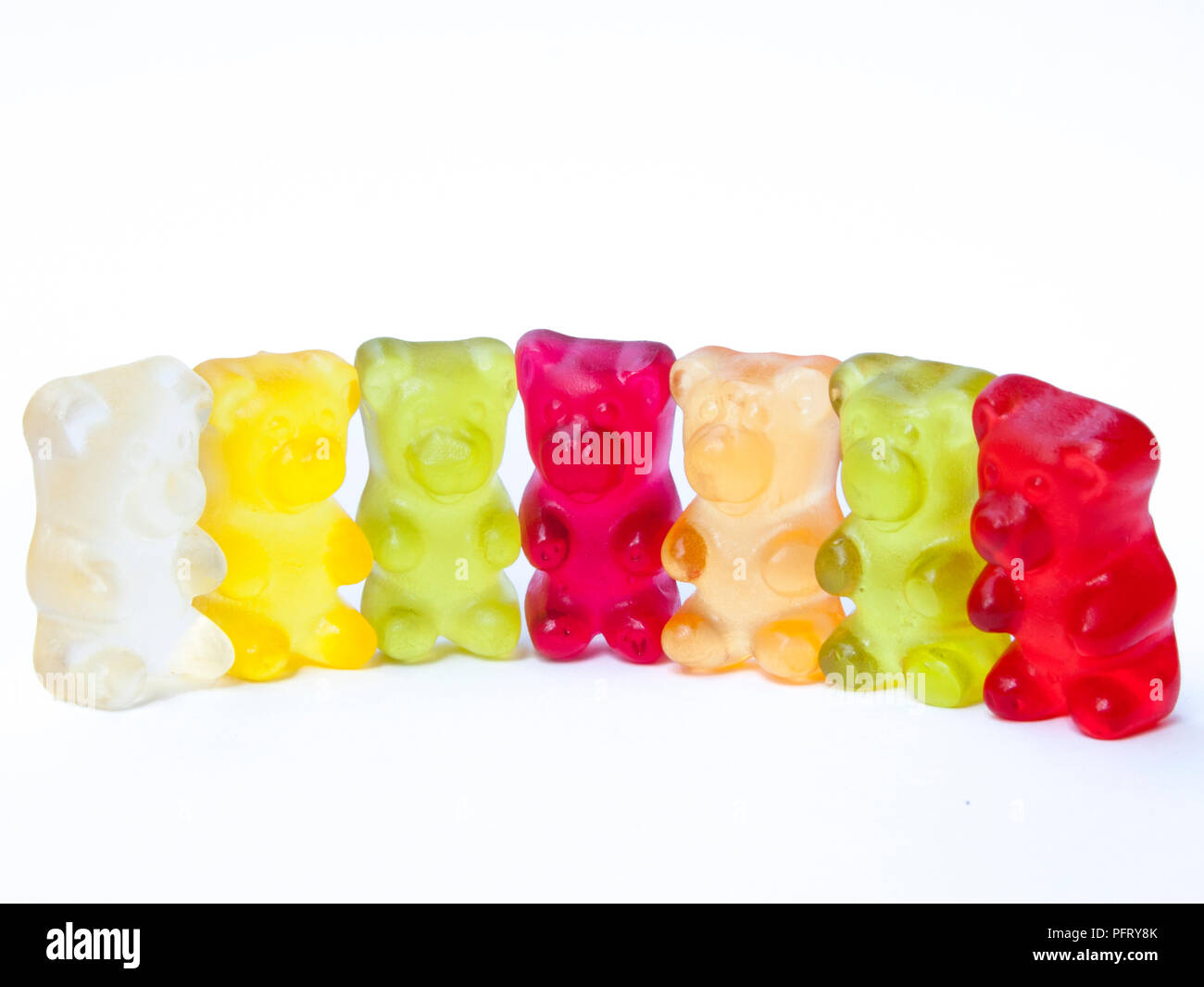 Gummy bears candy in una riga bianca su sfondo isolato. Foto Stock