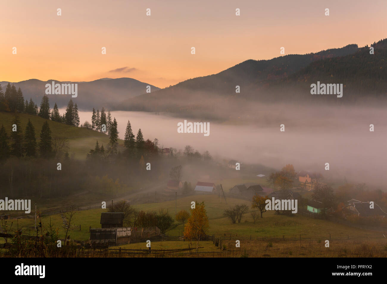 Colorato paesaggio autunnale nel villaggio di montagna. Mattinata nebbiosa nelle montagne dei Carpazi, Ucraina Foto Stock