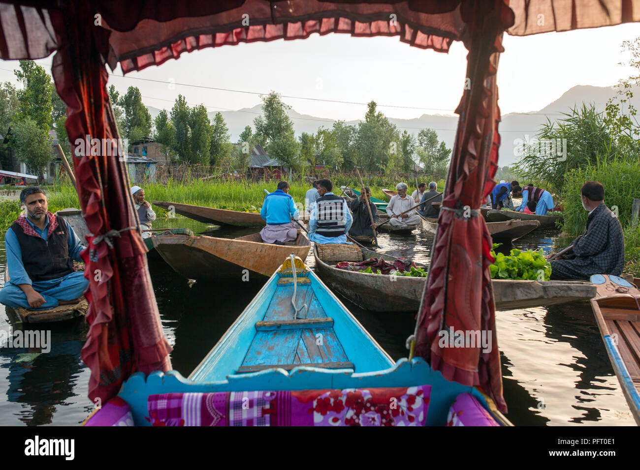 Srinagar, India - 16 Giugno 2017: Non identificato venditori vegetali tenendo i loro produrre per il mercato galleggiante di mattina presto su dal lago in Srina Foto Stock